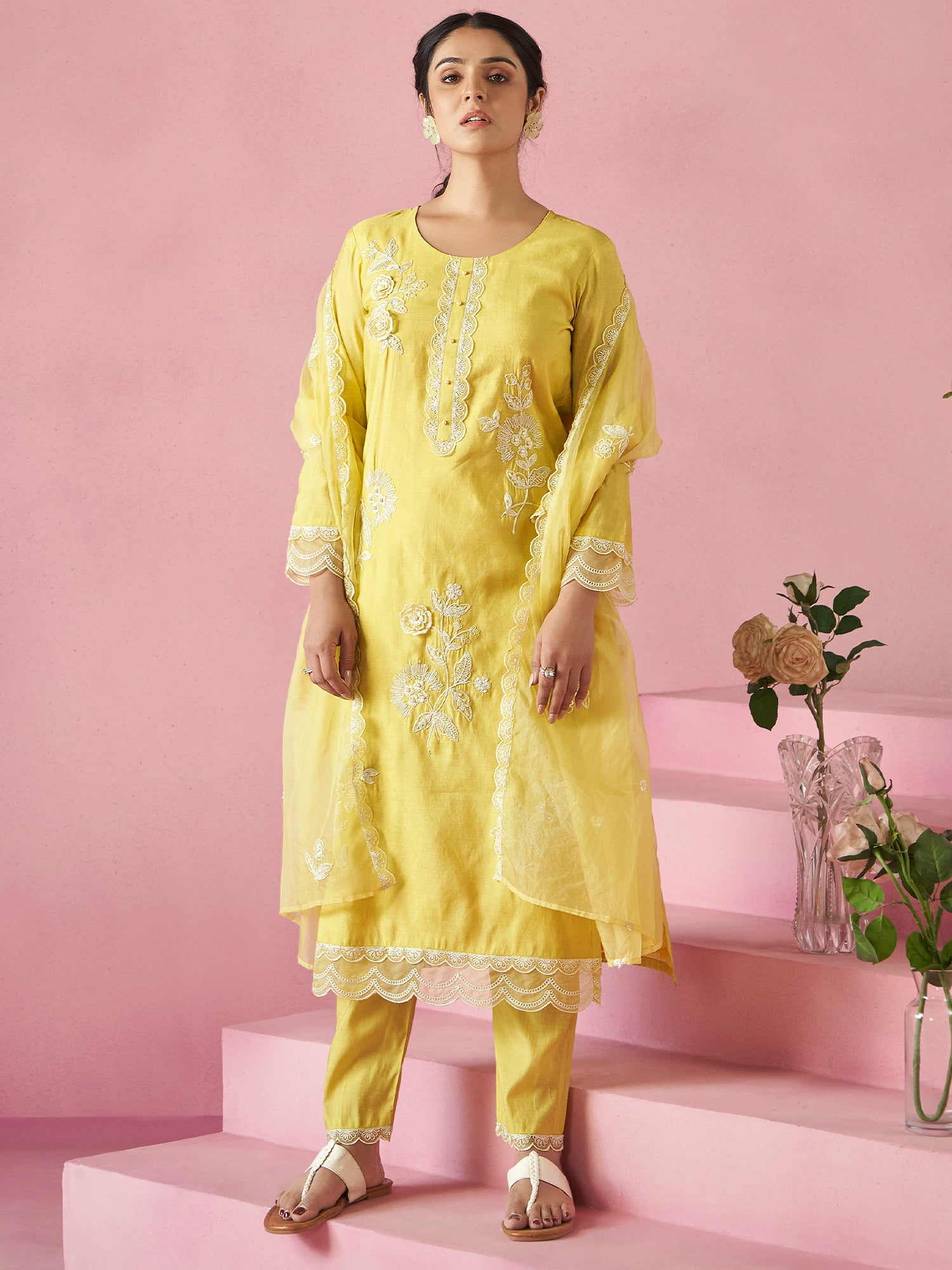 Women wearing yellow kurta set with yellow trouser and yellow dupatta with pink background