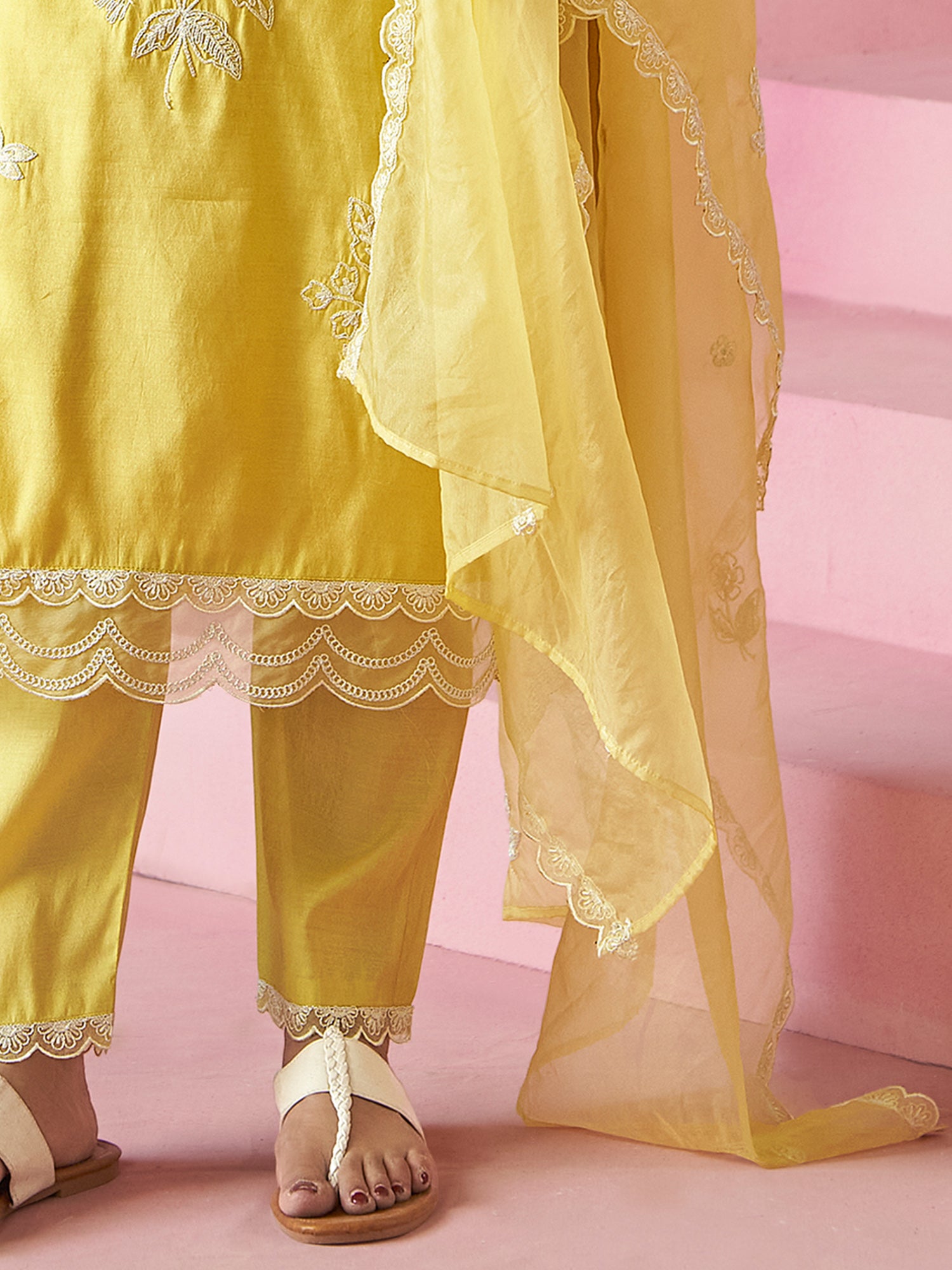 Yellow embroidered outfit with a pink background